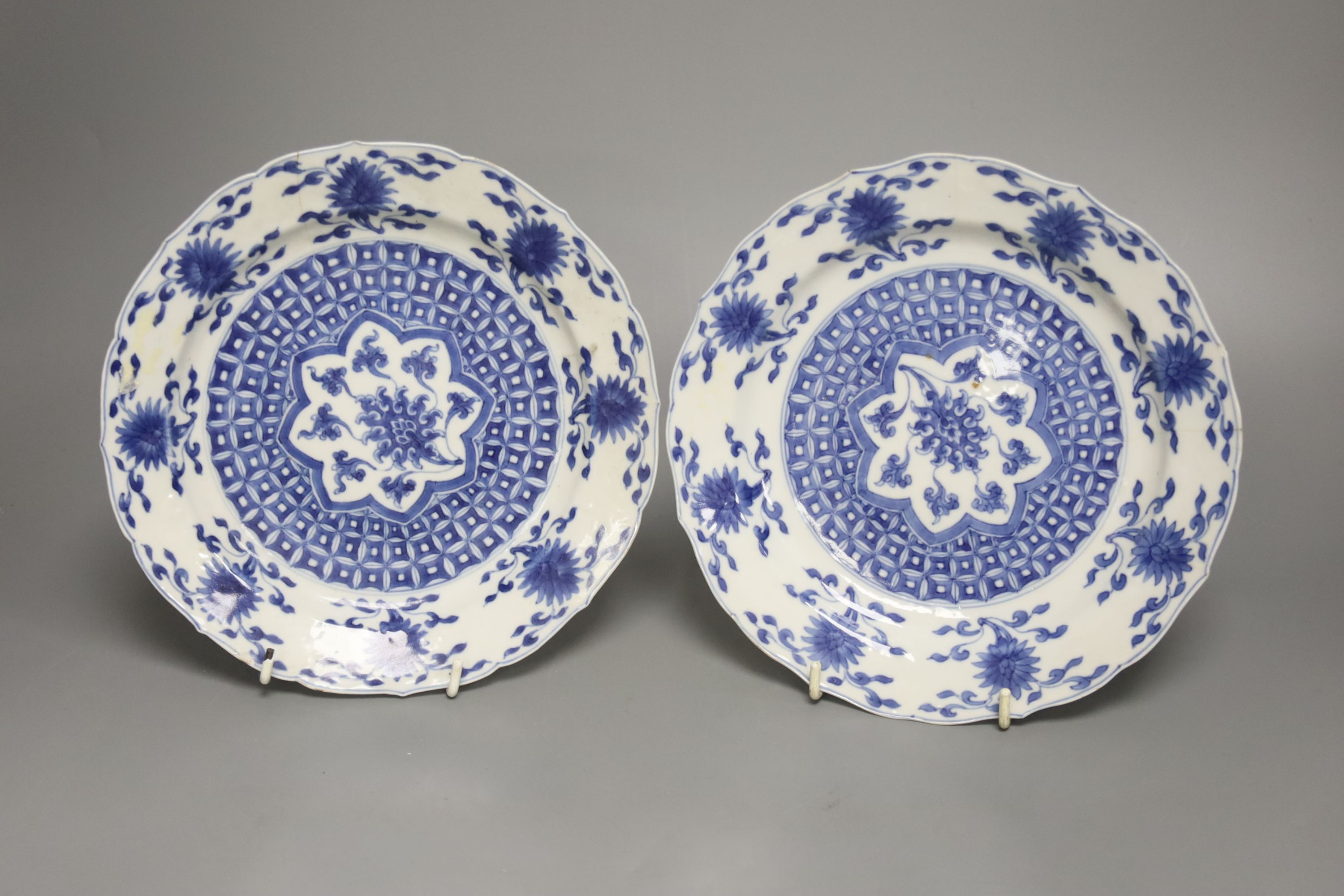 A pair of Chinese blue and white porcelain plates, Kangxi mark and period, with shaped borders and floral motifs, diameter 20cm